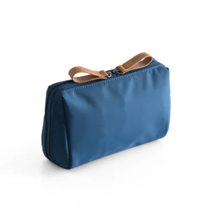 Blue toiletry bag with a brown strap on a white background