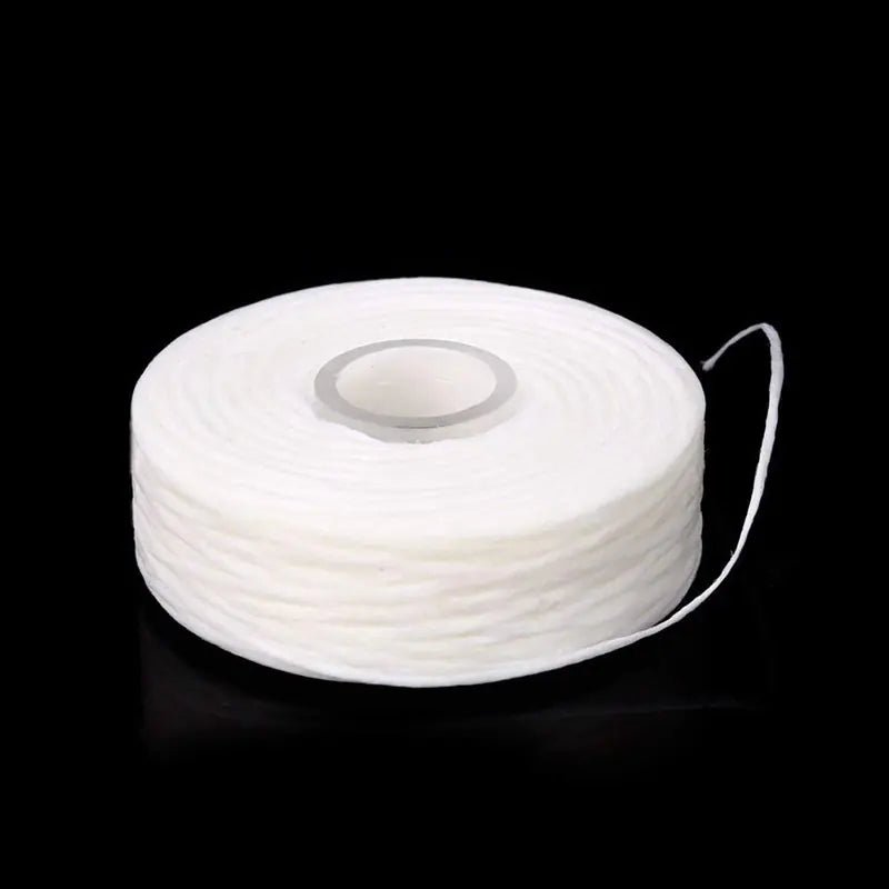 White spool of thread on a black background