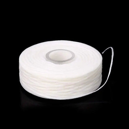 White spool of thread on a black background