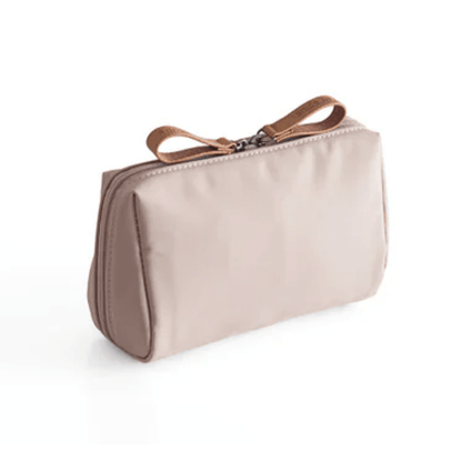 Beige toiletry bag with brown strap on a white background